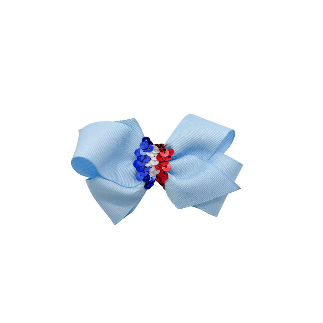 Light Blue grosgrain hair bow with sequin trim center. Made with an alligator Hair clip or elastic headband