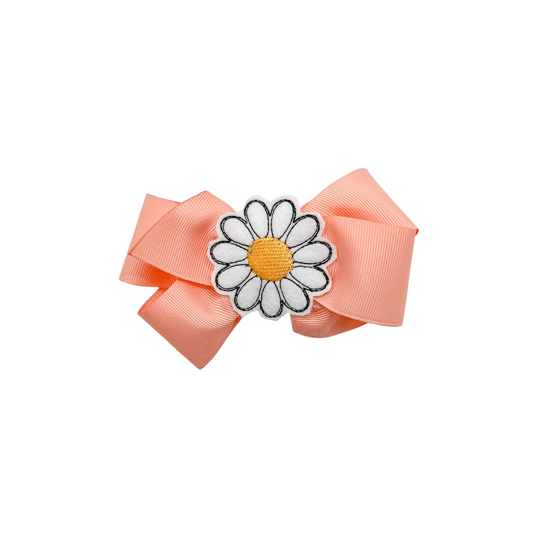 Peach bow with embroidered Daisy face center 1.5in Grosgrain Hair bow . Made with an alligator Hair clip or elastic headband
